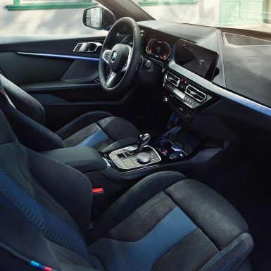 Aménagement intérieur sportif de la BMW Série 1. Le poste de conduite de la BMW Série 1 avec sièges M sport, volant M en cuir et inserts de décoration éclairés.