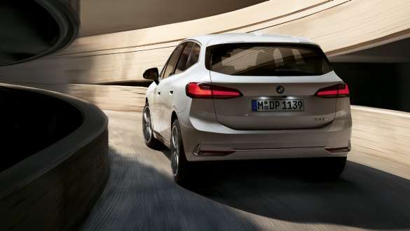 BMW Série 2 Active Tourer U06 2021 - design arrière dynamique BMW Série 2 Active Tourer U06 2021 Mineralweiß métallisé, montée de la rampe hélicoïdale d’un parking à étages, vue arrière