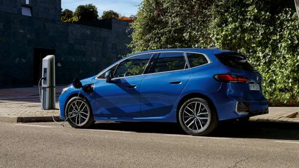 BMW Série 2 Active Tourer 230e Hybride Rechargeable U06 2021 stationnée à la borne de recharge BMW Série 2 Active Tourer 230e Hybride Rechargeable U06 2021 M Portimao Blau métallisé stationnée à la borne de recharge, vue de côté