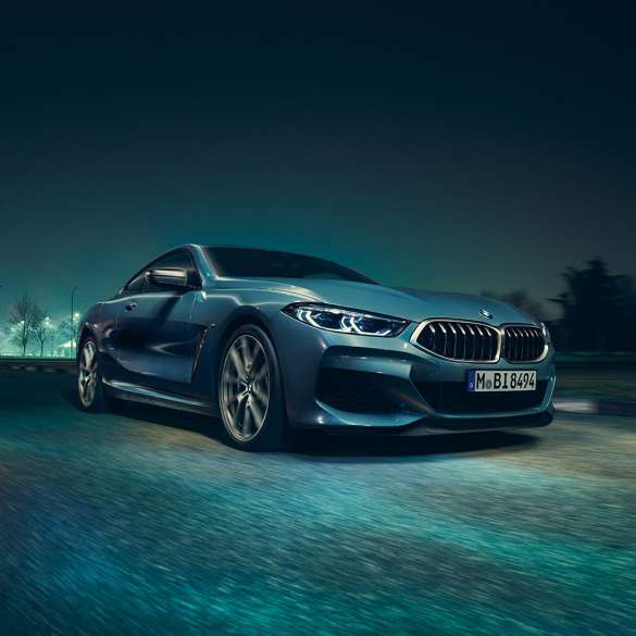 BMW M850i xDrive Coupé, vue de trois quarts avant gauche. BMW M850i xDrive Coupé en Barcelona Blau metallic, vue de trois quarts avant gauche, en marche, de nuit.