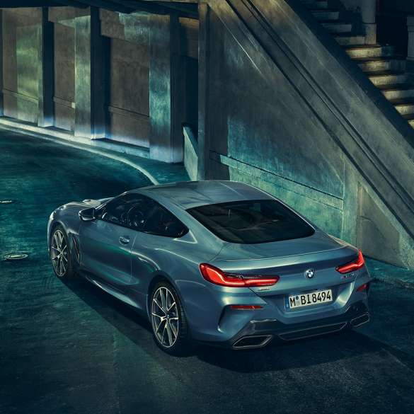 BMW M850i xDrive Coupé, vue de trois quarts arrière gauche. BMW M850i xDrive Coupé en Barcelona Blau metallic, vue de trois quarts arrière gauche, à l’arrêt, de nuit.