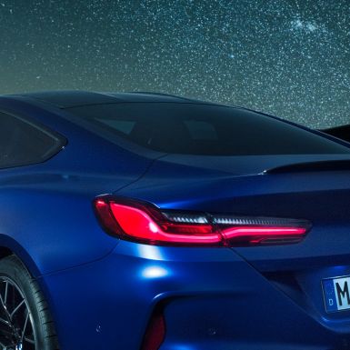 Becquet M arrière BMW M8 Competition Coupé en Marina Bay Blau metallic, vue en gros plan de la carrure de nuit, avec diffuseur M en Carbon Schwarz.