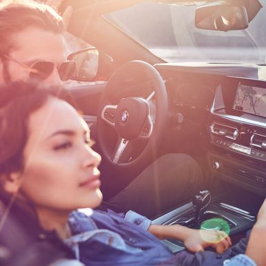 Homme et femme à bord de la BMW Z4 Roadster Femme aux cheveux bruns et homme à bord de la BMW Z4 Roadster
