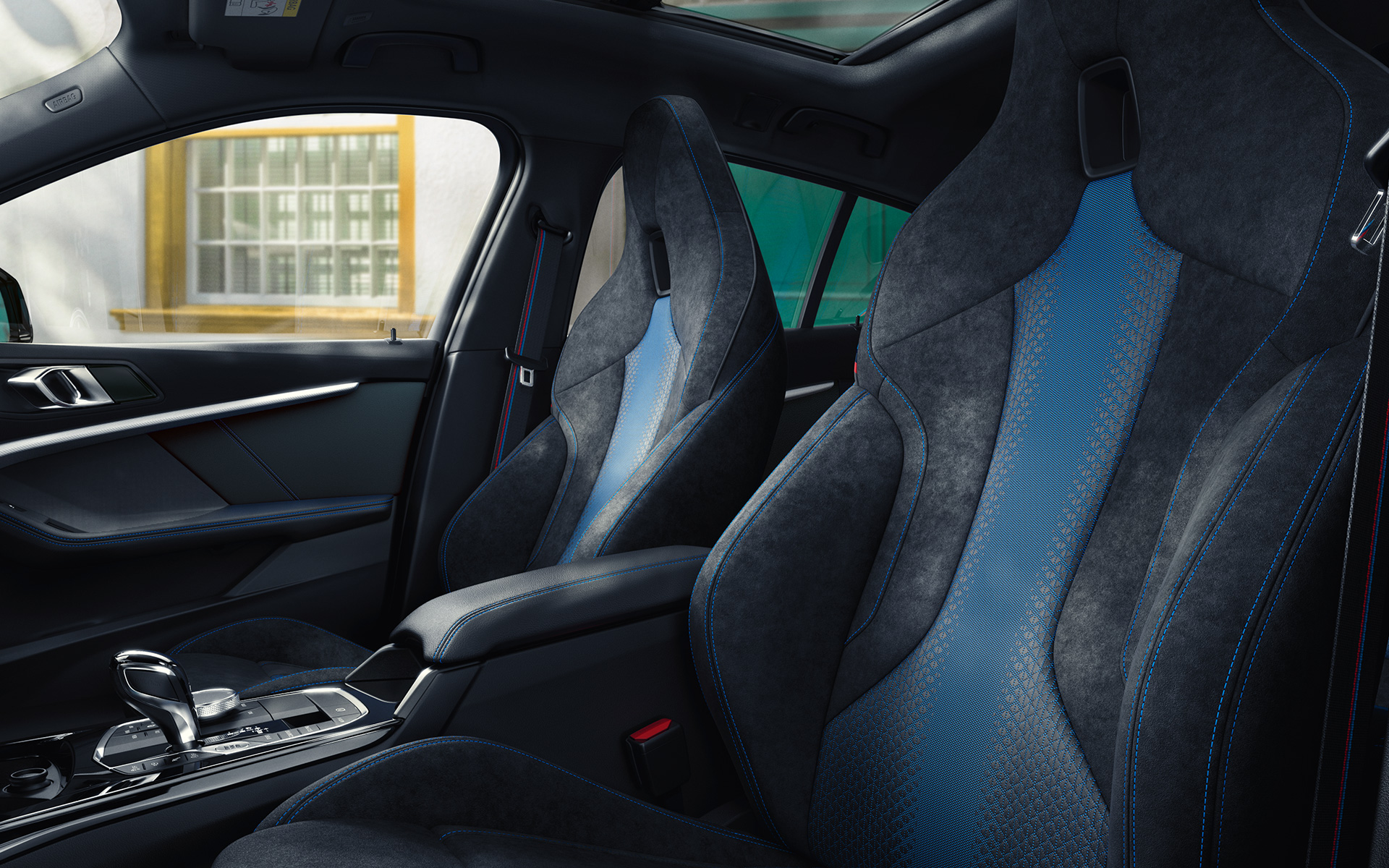Sièges M sport au galbe ergonomique de la BMW Série 1 F40, avec surpiqûres contrastées bleues et appuie-têtes intégrés.
