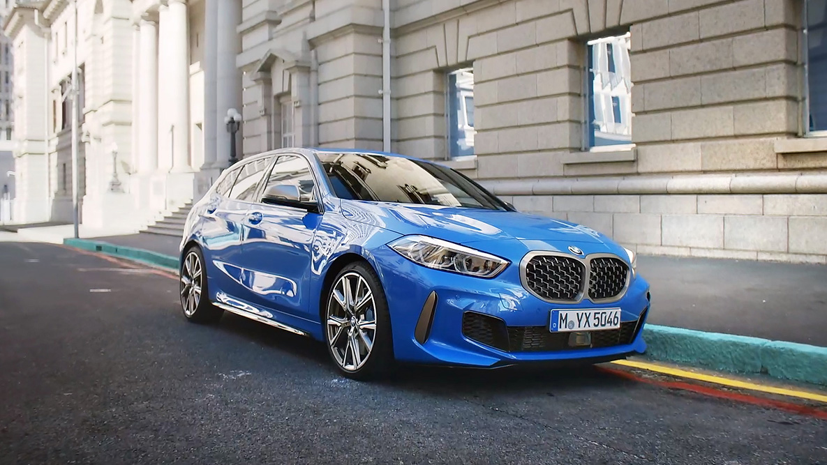 La BMW Série 1 F40 en Misano Blau metallic, vue de profil en stationnement.