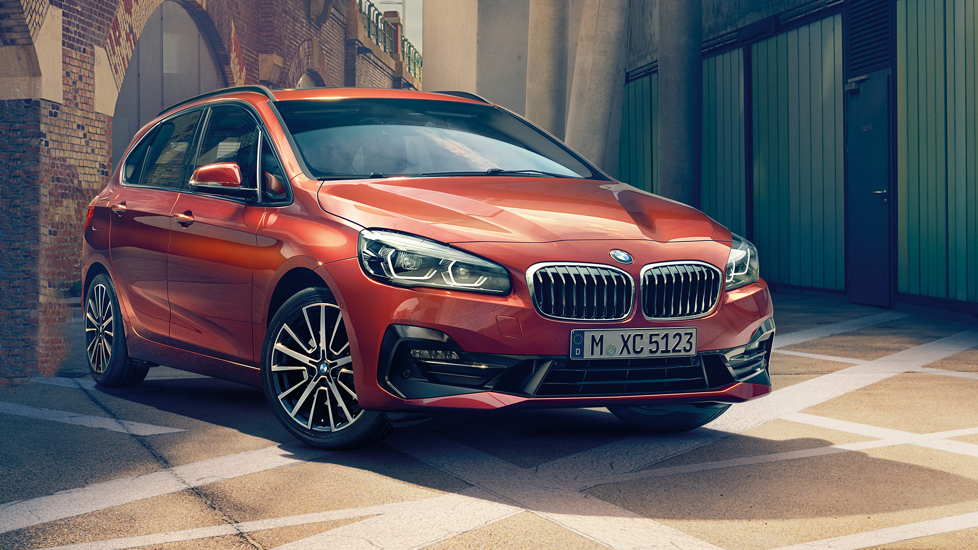 Extérieur de la BMW Série 2 Active Tourer BMW Série 2 Active Tourer F45 restylage 2018 Sunset Orange metallic, vue de trois quarts avant, en stationnement dans une ruelle