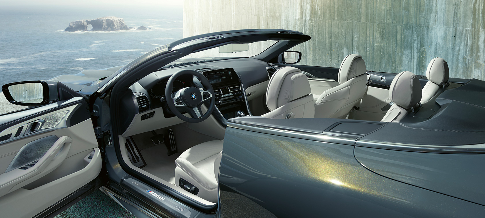BMW M850i xDrive Dravitgrau metallic, vue de profil, capote en tissu et porte ouverte. BMW M850i xDrive Dravitgrau metallic, vue de profil, capote en tissu et porte ouverte.