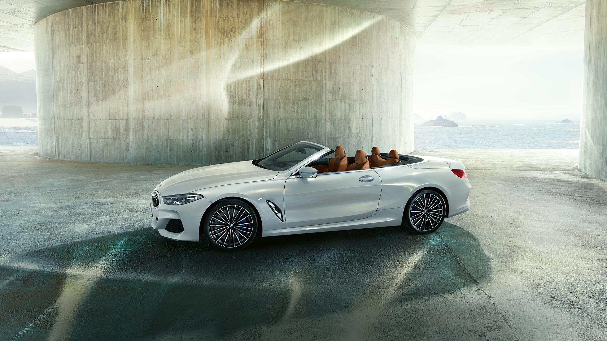 BMW M850i xDrive en Mineralweiß metallic, vue de profil avec capote souple ouverte. BMW M850i xDrive en Mineralweiß metallic, vue de profil avec capote souple ouverte.