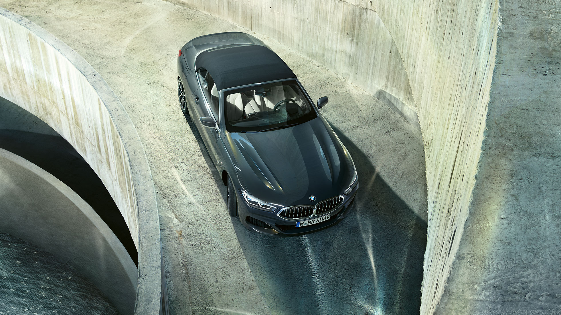 BMW M850i xDrive Dravitgrau metallic avec capote en tissu noire, vue en plongée. BMW M850i xDrive Dravitgrau metallic avec capote en tissu noire, vue en plongée.