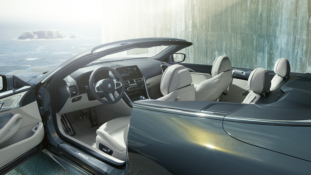 BMW M850i xDrive Dravitgrau metallic, intérieur, capote en tissu et porte ouverte. BMW M850i xDrive Dravitgrau metallic, intérieur, capote en tissu et porte ouverte.
