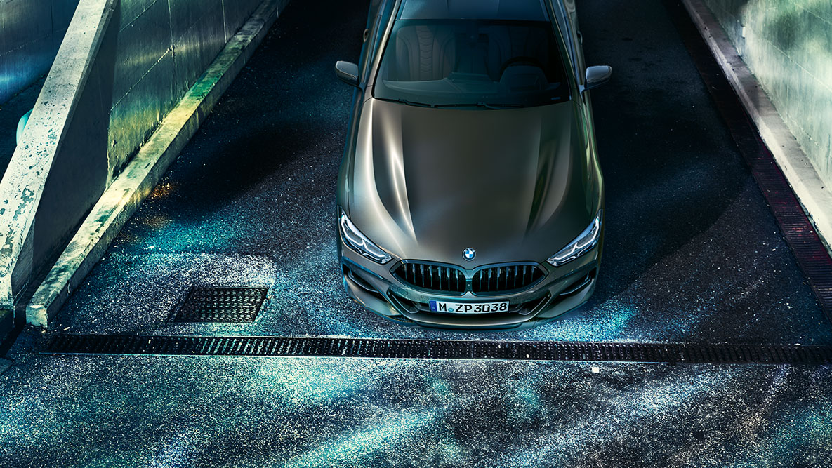 La BMW Série 8 Coupé photographiée à l'arrêt de face. La BMW Série 8 Coupé avec équipement BMW Individual, photographiée à l'arrêt de face, dans un décor urbain de nuit.
