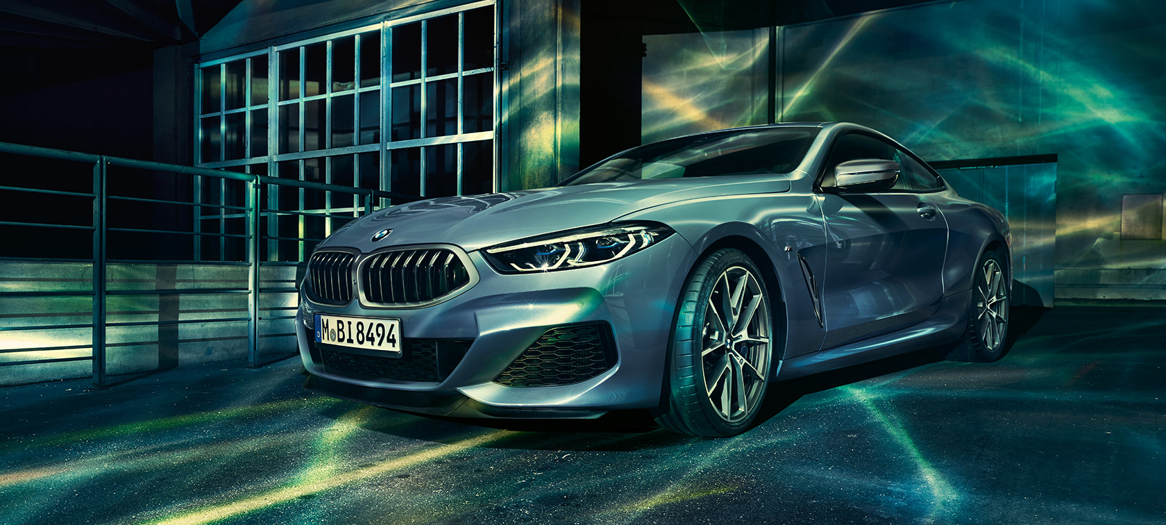 La BMW Série 8 Coupé, vue de trois quarts face. La BMW Série 8 Coupé, vue de trois quarts face, devant des bâtiments industriels.