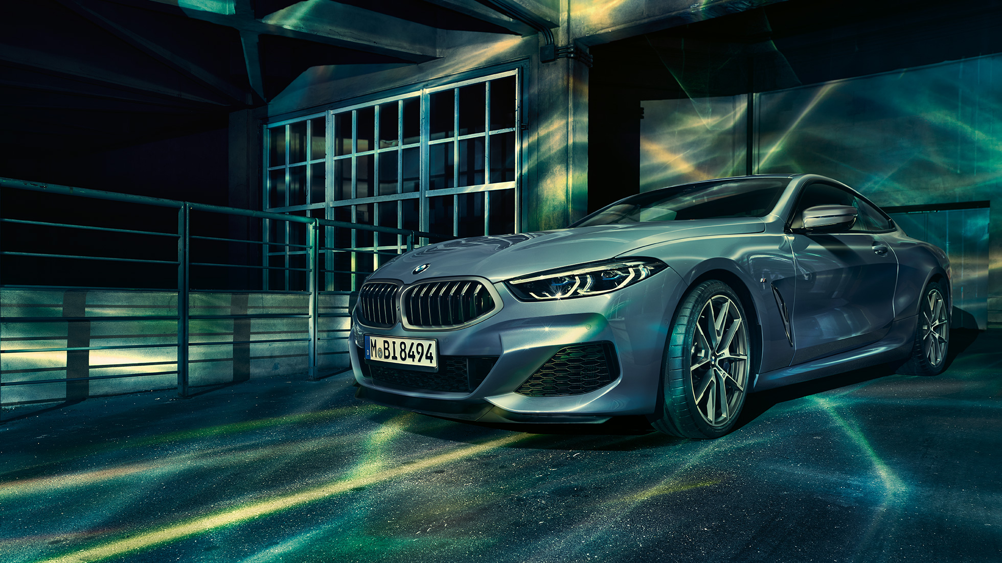 BMW M850i xDrive Coupé, vue de trois quarts avant. BMW M850i xDrive Coupé en Barcelona Blau metallic, vue de trois quarts avant à l’arrêt devant un immeuble.