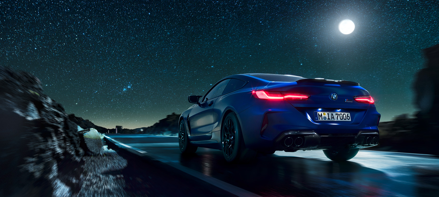 BMW M8 Competition Coupé, vue arrière. BMW M8 Competition Coupé, vue arrière, conduite de nuit avec pleine lune.