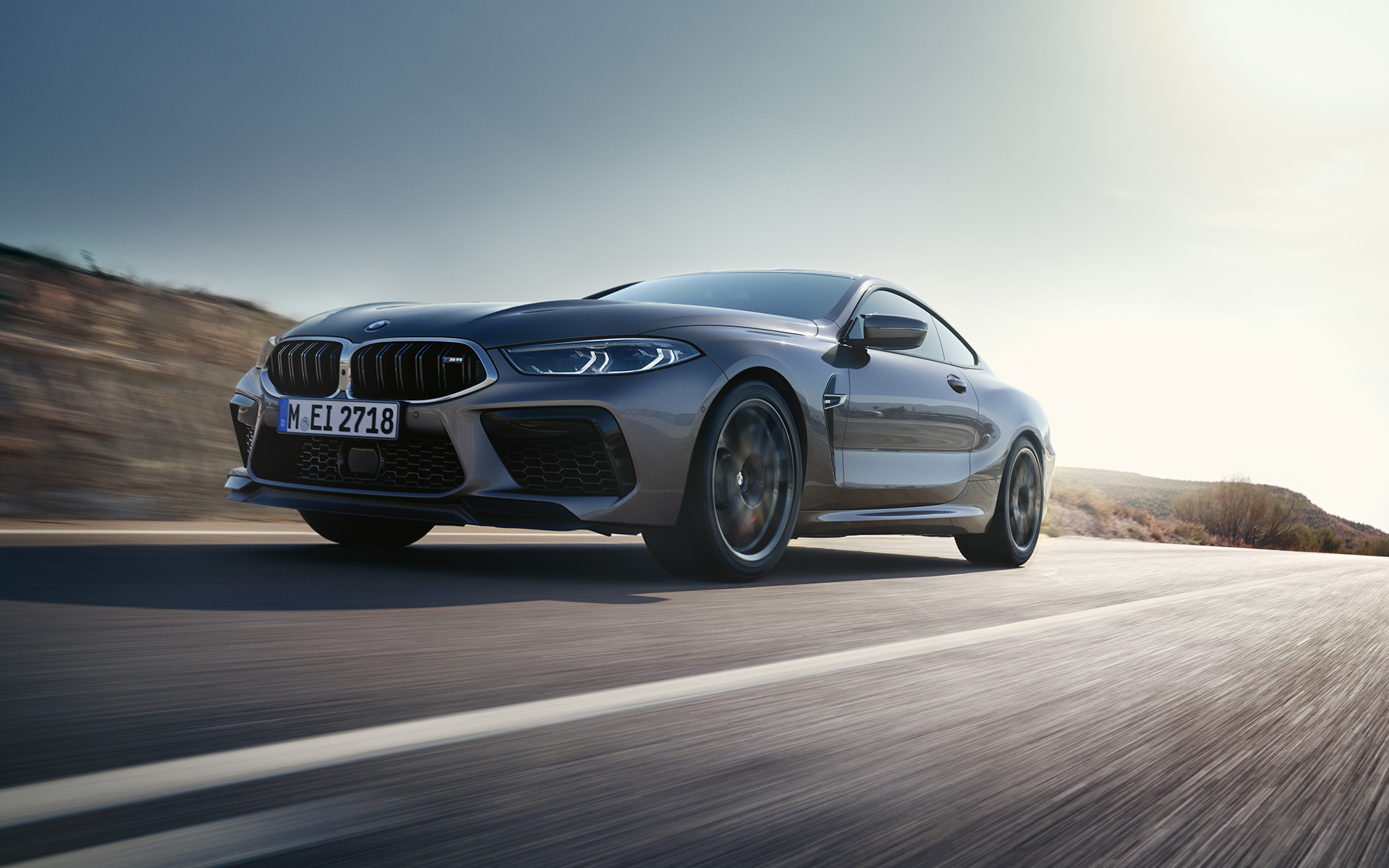 BMW M8 Coupé F92 LCI Facelift 2022 Skyscraper grey metallic three-quarter front view driving on a highway low angle shot
