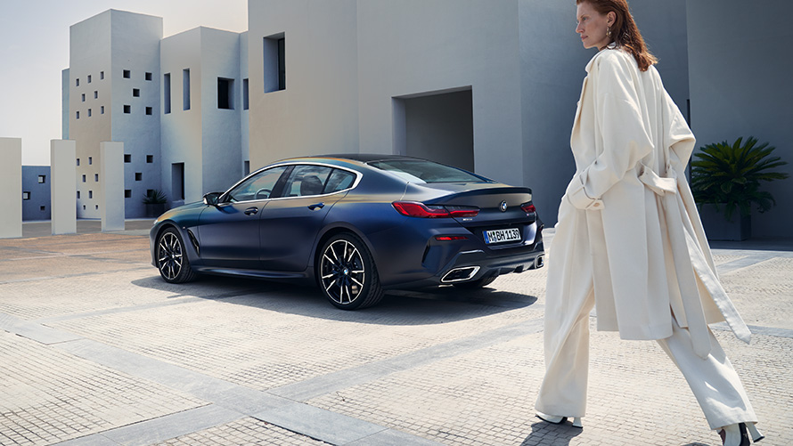 BMW M850i xDrive Gran Coupé G16 LCI restylage 2022 BMW Individual Frozen Tansanitblau metallic vue de trois quarts arrière avec modèle féminin