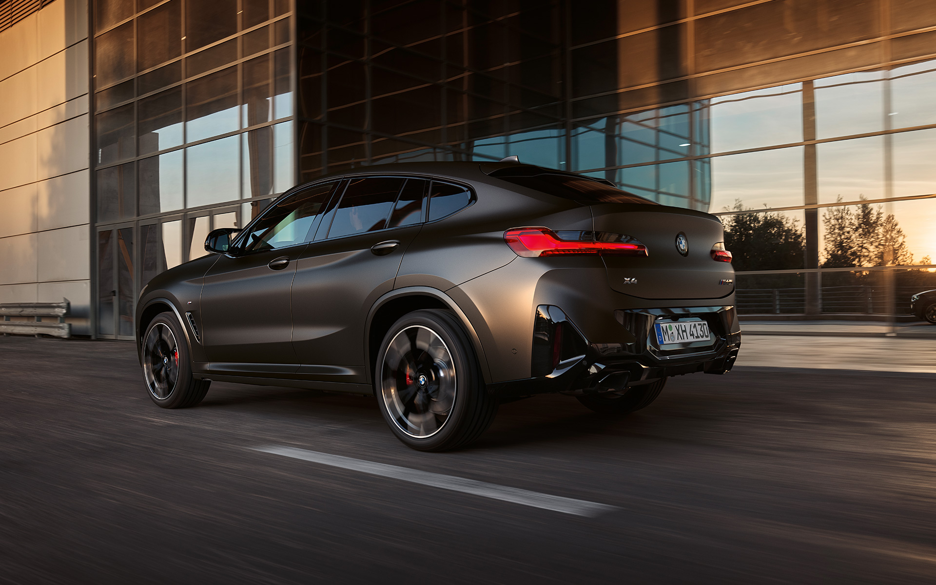 BMW X4 M40i G02 LCI 2021 Facelift vue de trois quarts arrière devant une façade en verre