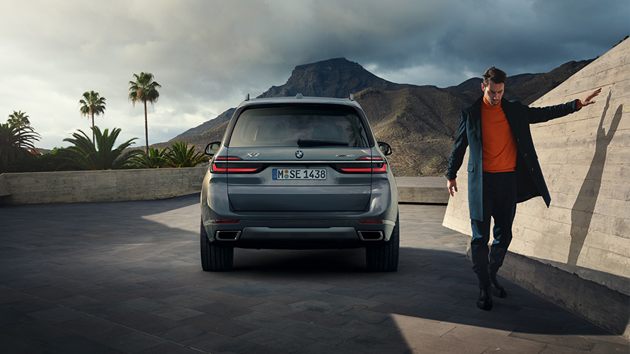 BMW X7 G07 LCI Vue arrière avec modèle à droite Sparkling Kupfergrau metallic