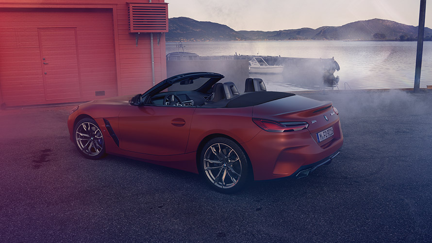 Vue arrière de la BMW Z4 première édition Vue arrière de la BMW Z4 première édition devant la maison rouge sur la rive.
