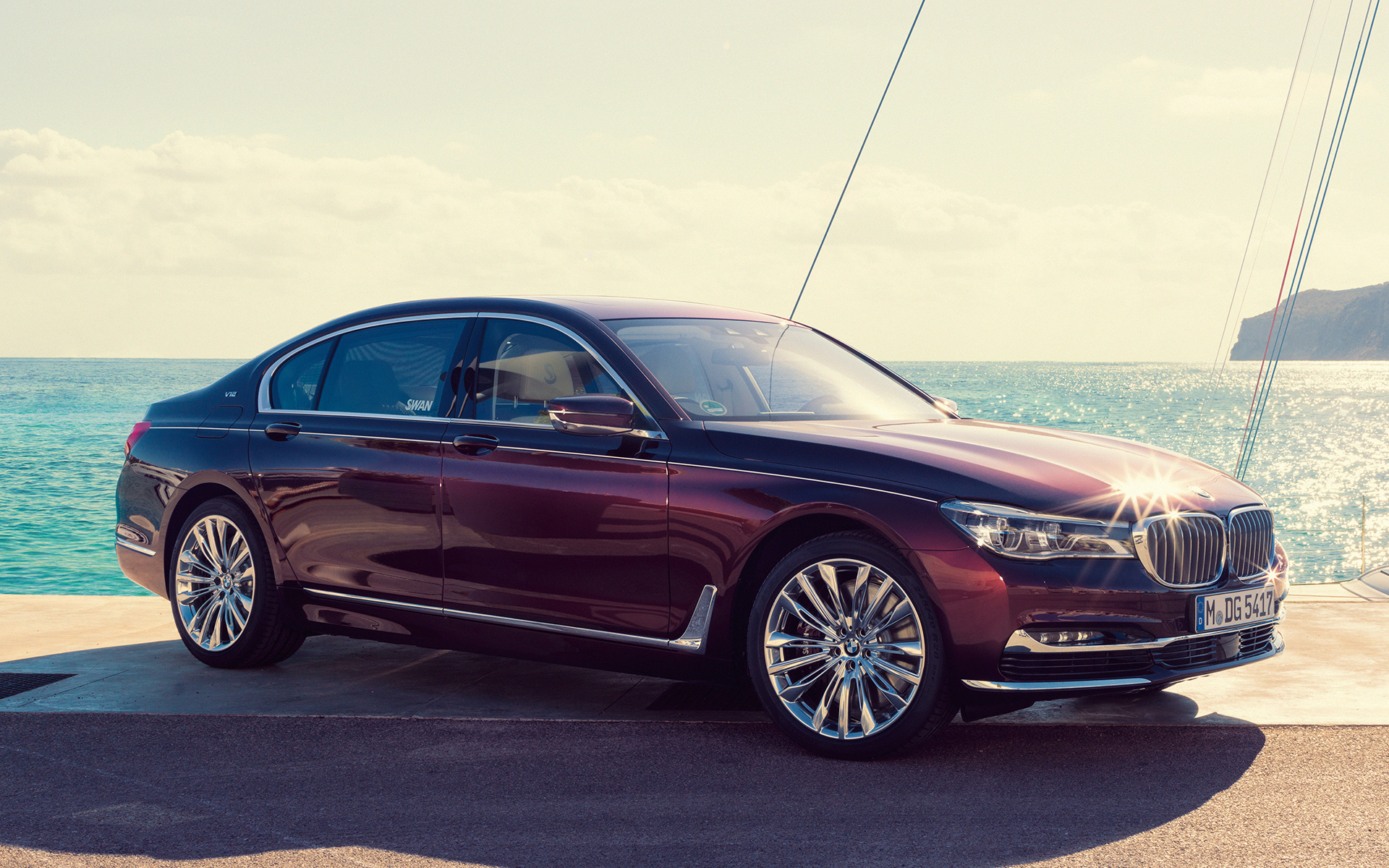 BMW Individual M760Li inspirée par Nautor’s Swan G1 2017 devant un yacht à voile BMW Individual M760Li inspirée par Nautor’s Swan G12 2017 vue trois quarts latérale à l'arrêt sur la jetée devant un yacht à voile dans une baie