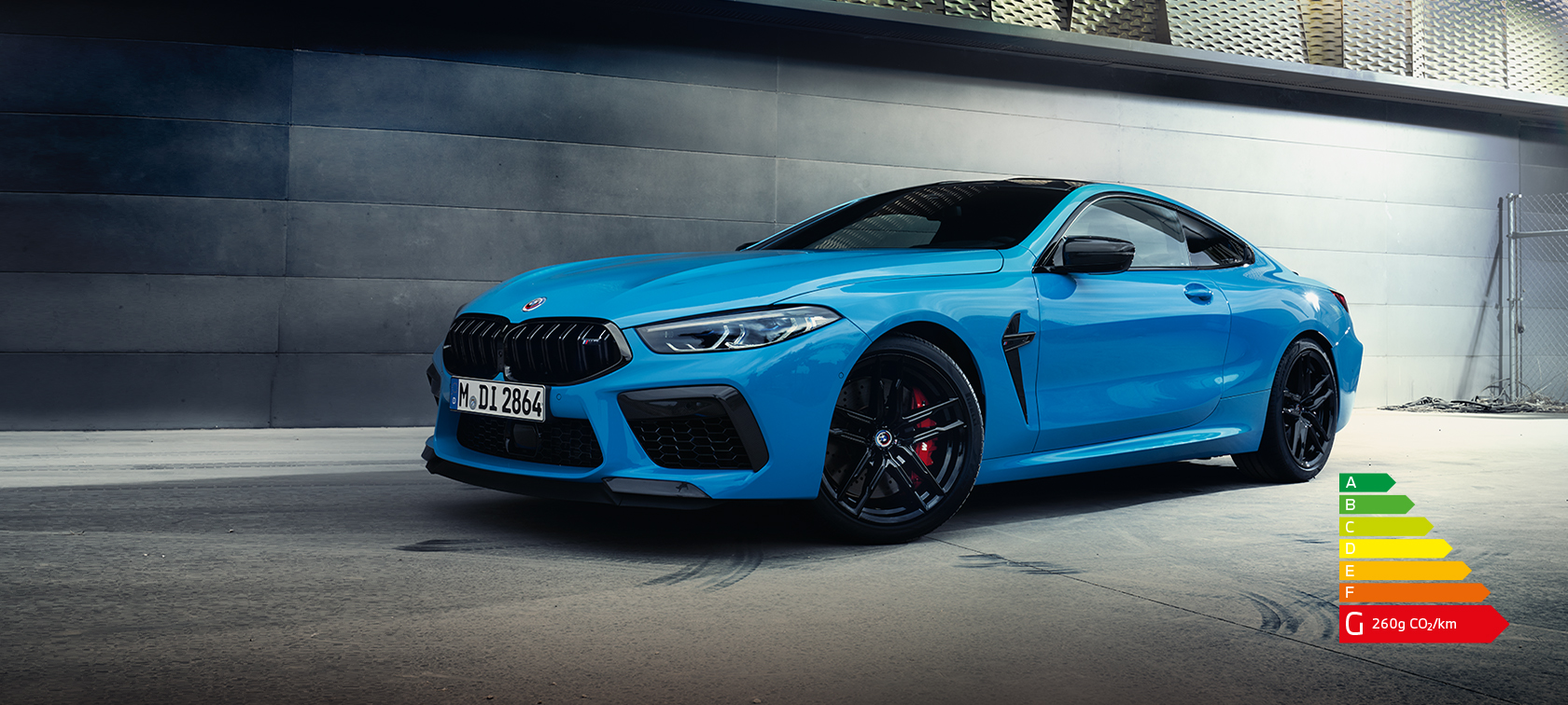 La BMW M8 Competition Coupé F92 LCI restylage 2022 Daytona Beach Blau uni Vue de profil de trois quarts face à un mur