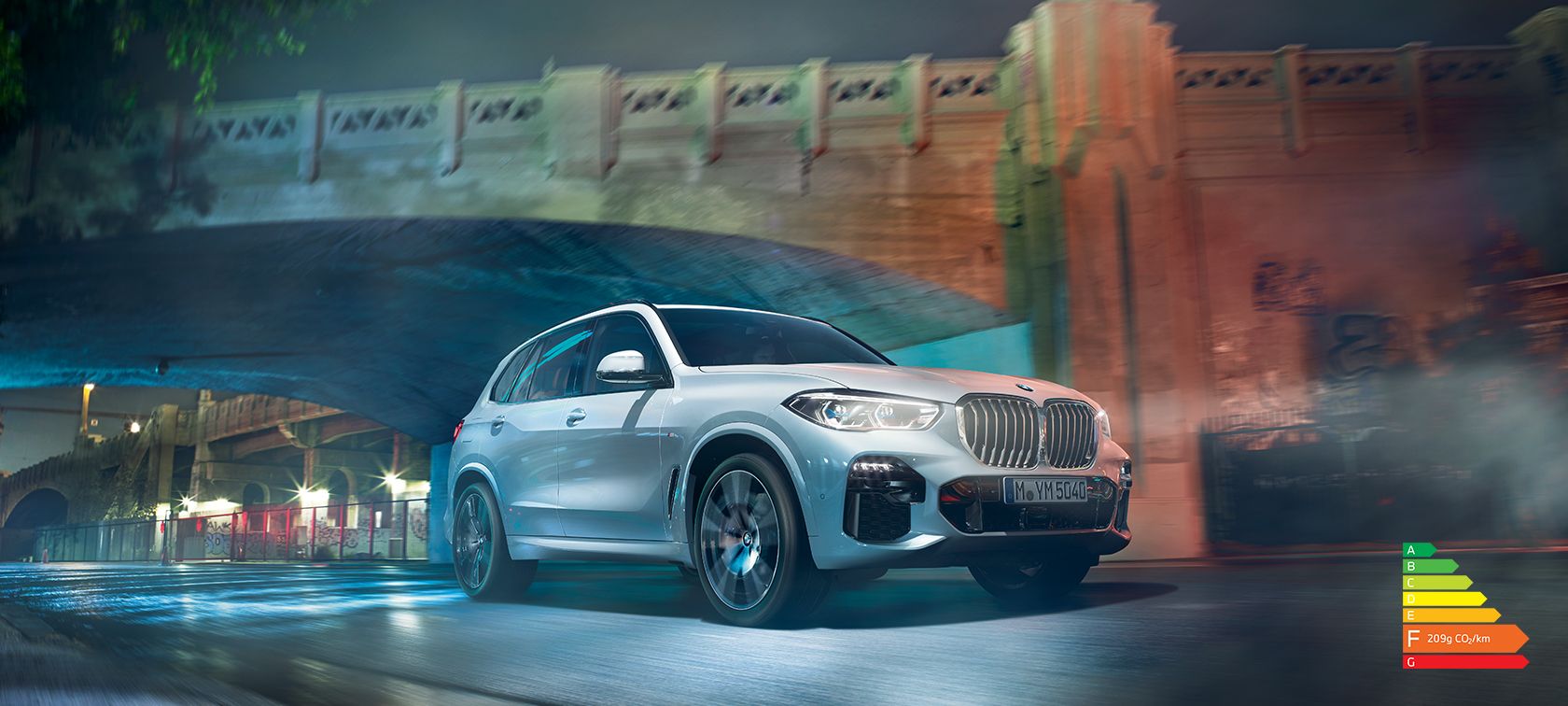 BMW X5 G05 2021 en Mineralwhite metallic vue de trois quarts avant en marche, de nuit